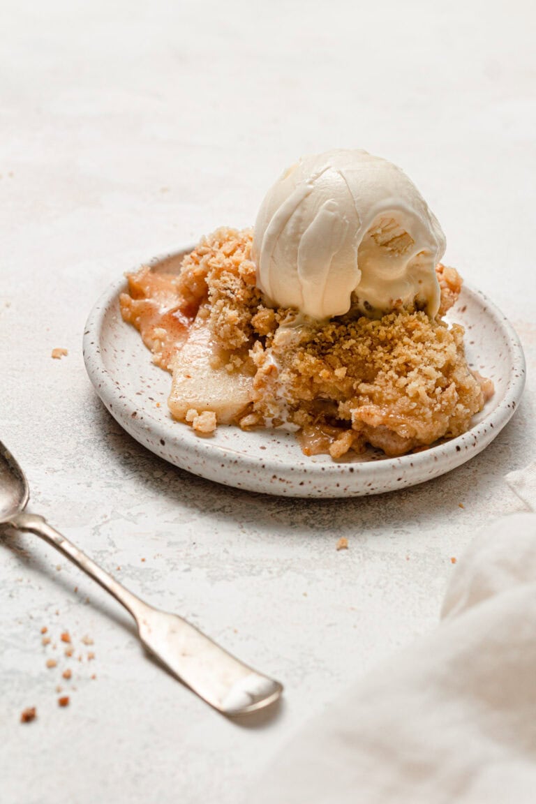 apple crisp on white plate with ice cream