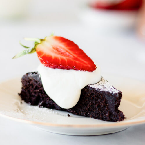 slice of flourless chocolate cake with cream and strawberry