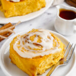 pumpkin cinnamon roll on a white plate