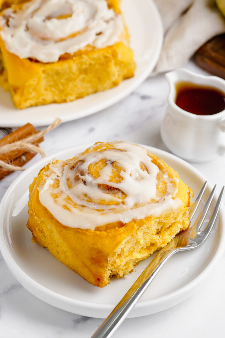 pumpkin cinnamon roll on a white plate
