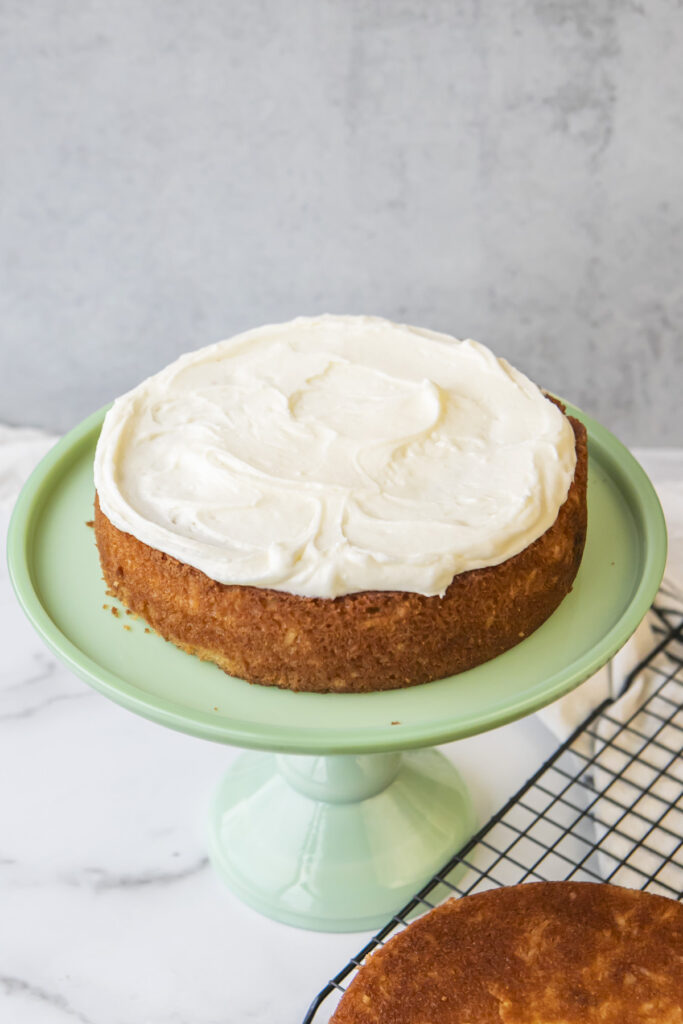 baked coconut cake with cream cheese frosting on top of it