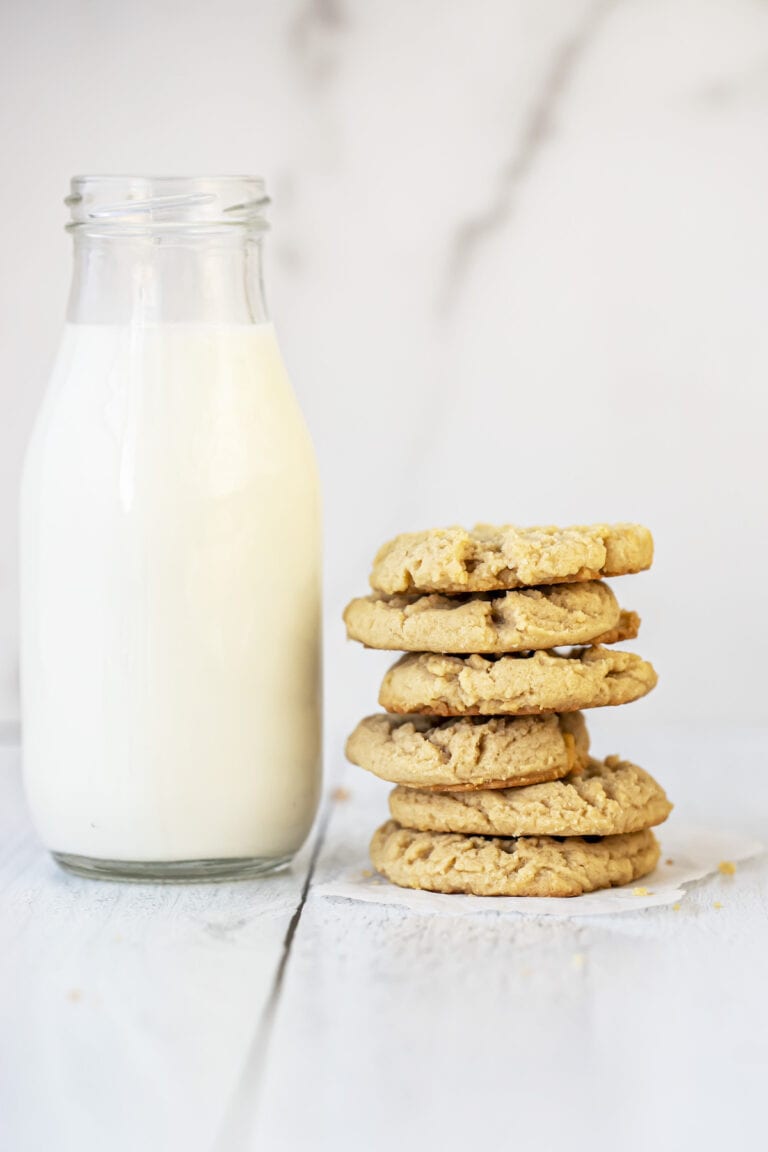 peanut butter cookies stacked on top of each other next to a glass of milk