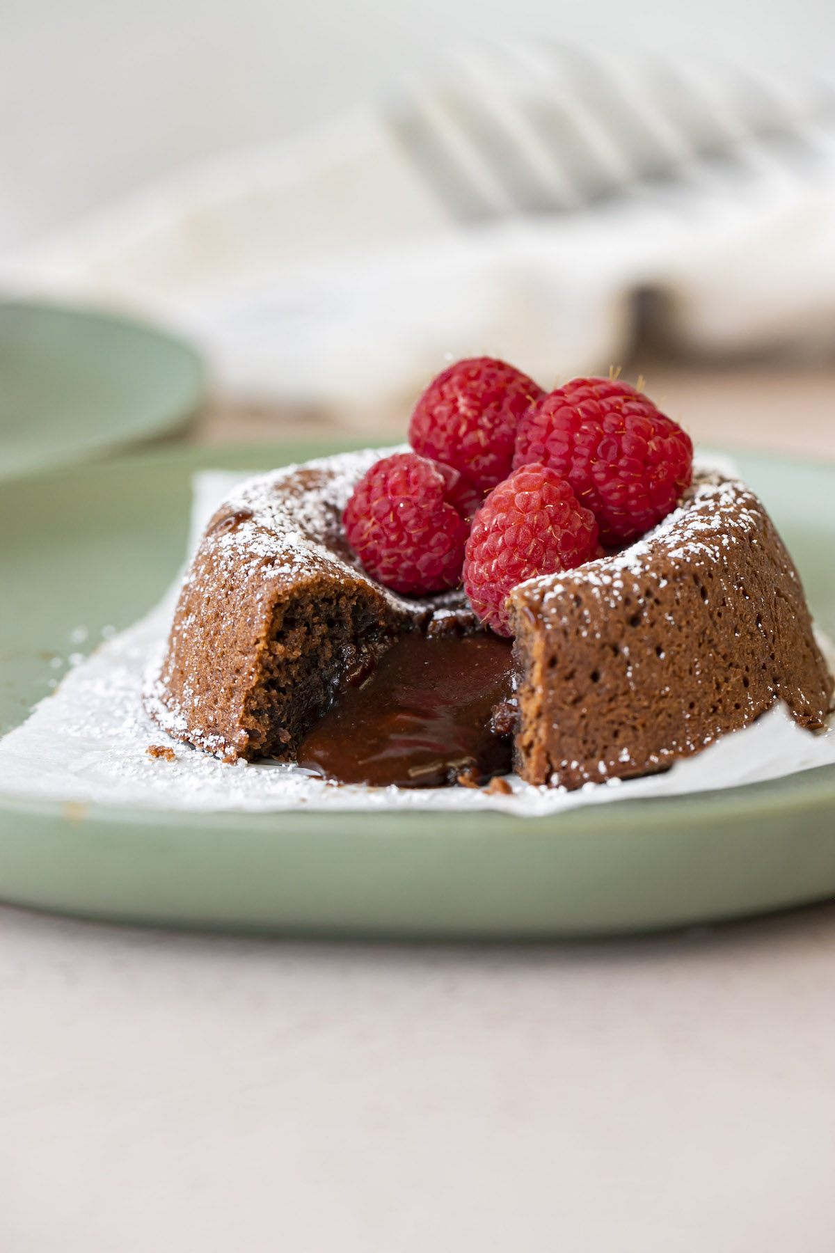 lava cake cut open with powdered sugar and raspberries on top