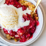 dump cake in white dish with ice cream on top