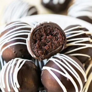 chocolate cake balls stacked on top of each other, one has a bite taken out of it