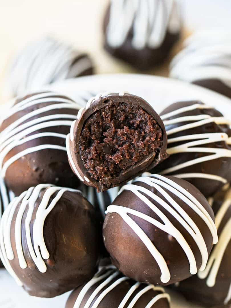 chocolate cake balls stacked on top of each other, one has a bite taken out of it