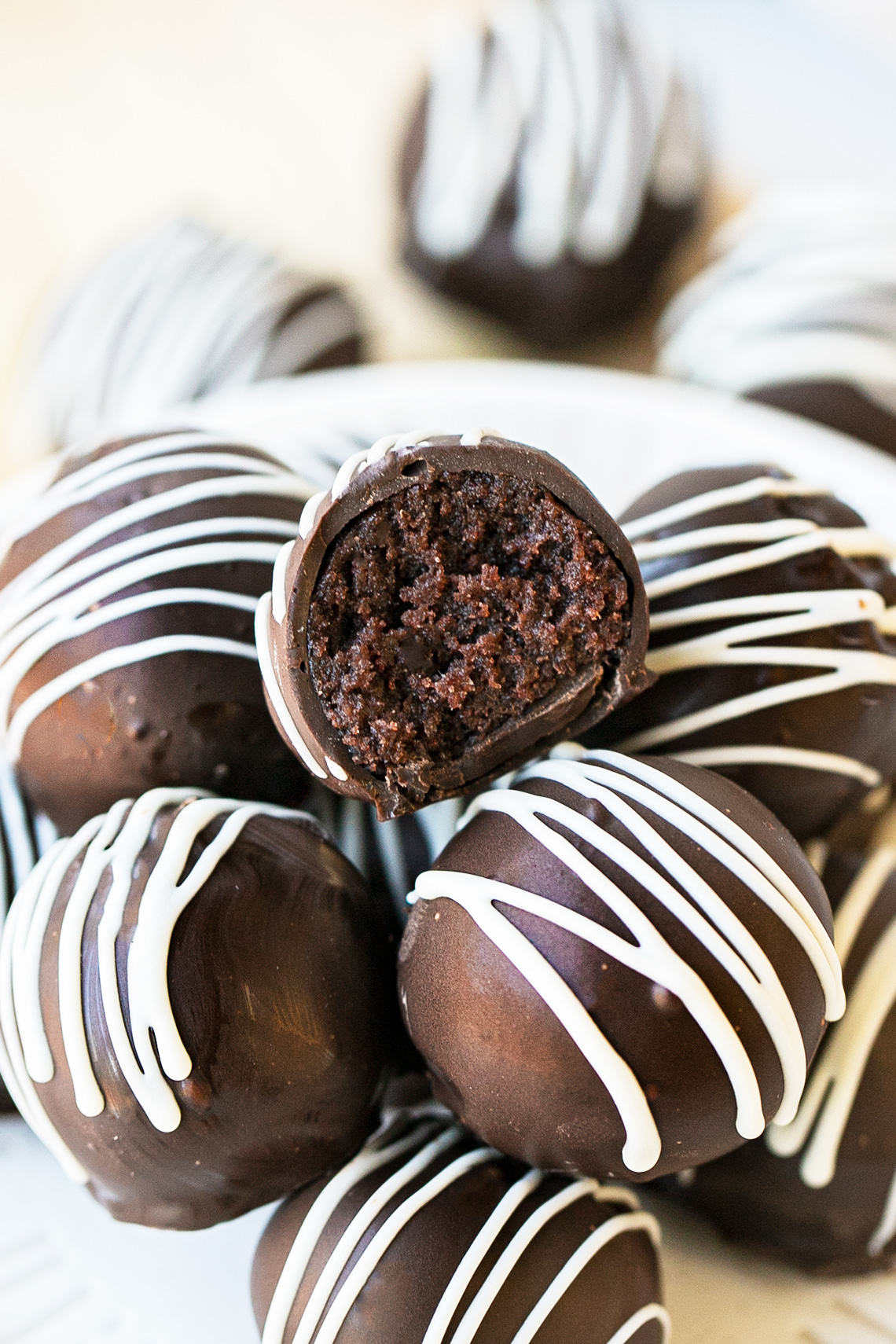 chocolate cake balls stacked on top of each other, one has a bite taken out of it