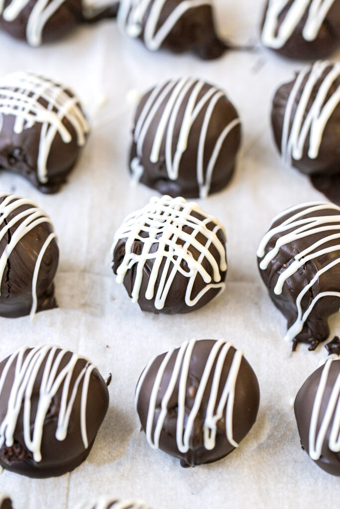 cake balls with a white chocolate drizzle