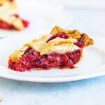 side view of baked cherry pie slice on a plate