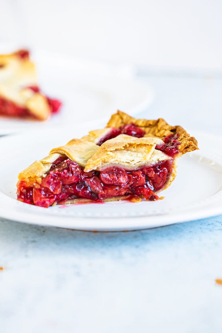 side view of baked cherry pie slice on a plate