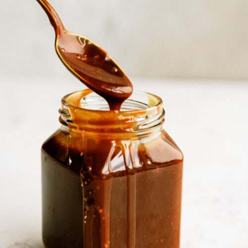 spoon exiting a jar full of salted caramel