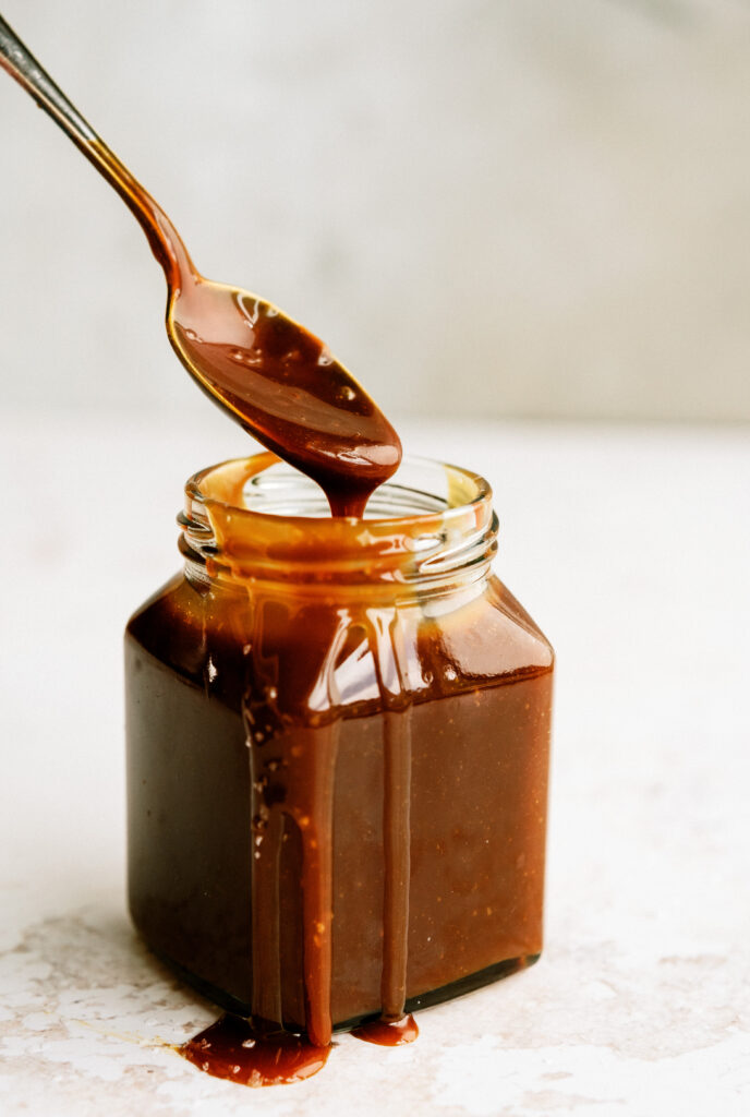 spoon exiting a jar full of salted caramel