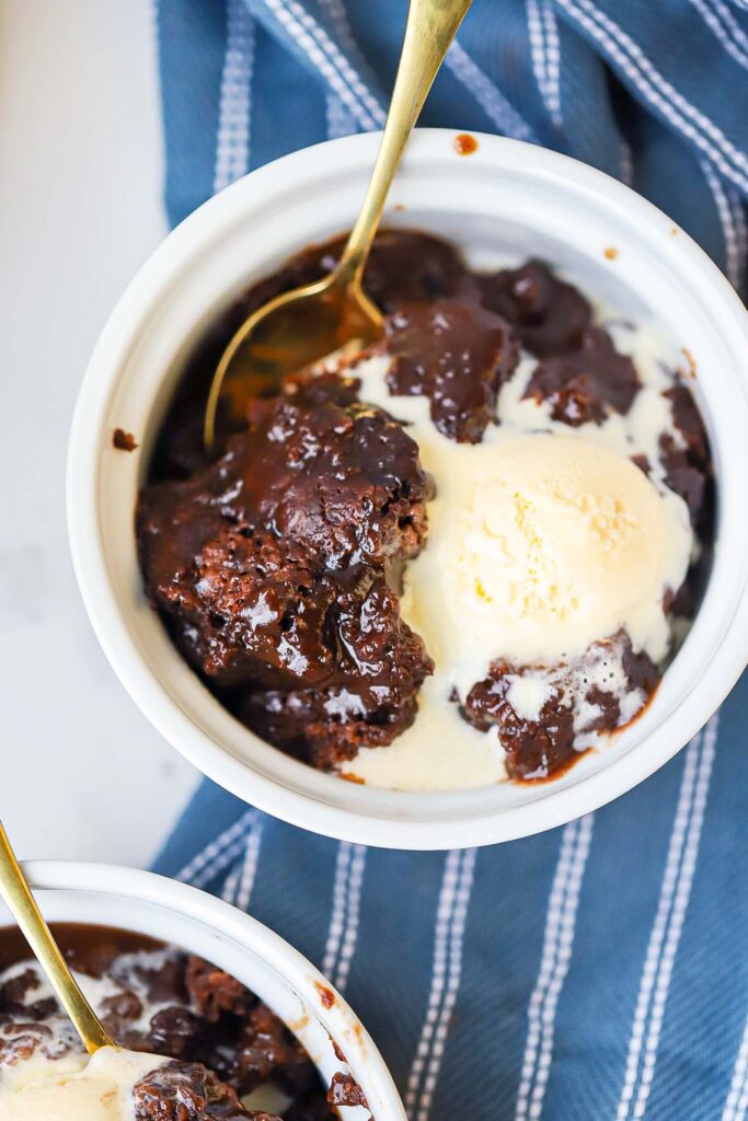 Overhead photo of chocolate cobbler in a bowl with a scoop of vanilla ice cream