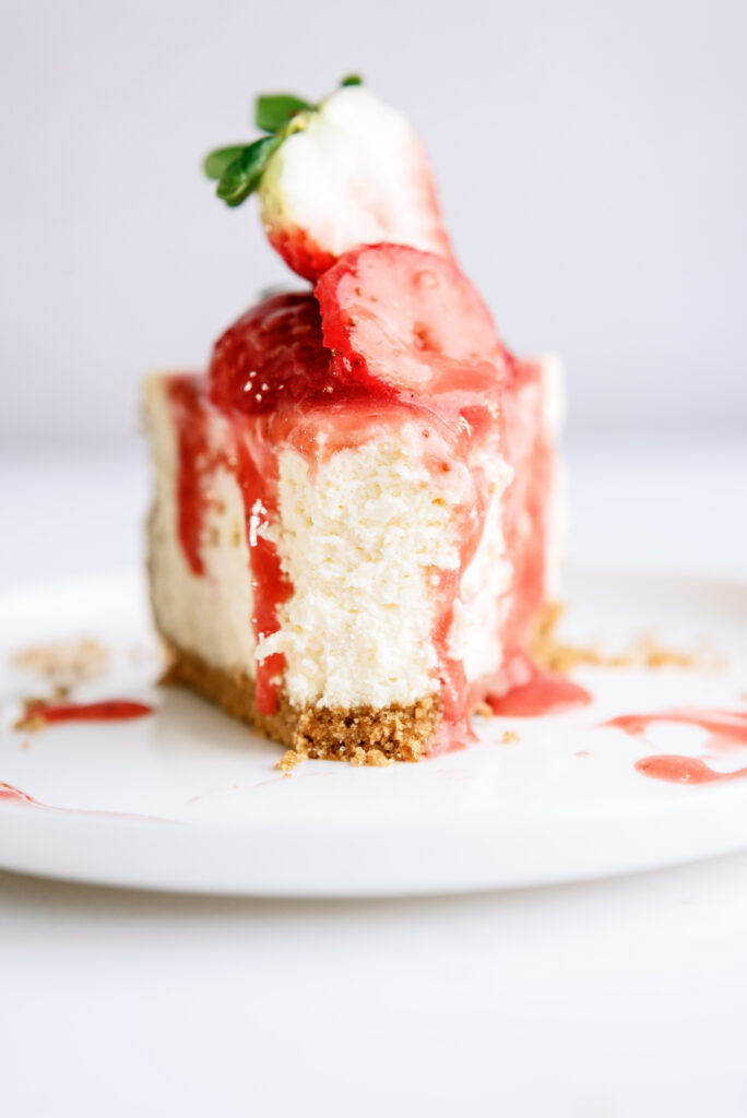 slice of strawberry cheesecake with a bite taken out of it