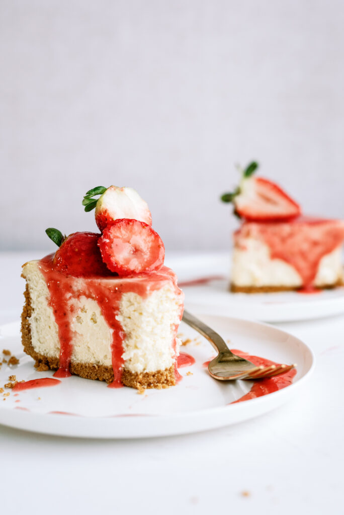 strawberry cheesecake on a plate with a bite taken out of it