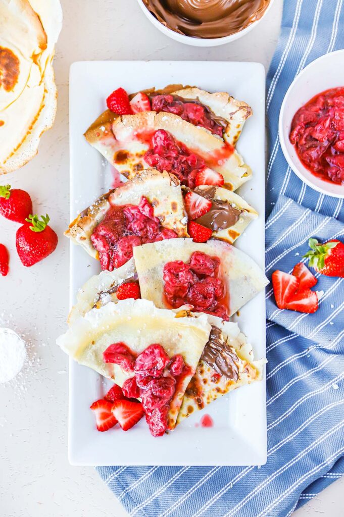 Nutella crepes topped with roasted and fresh strawberries