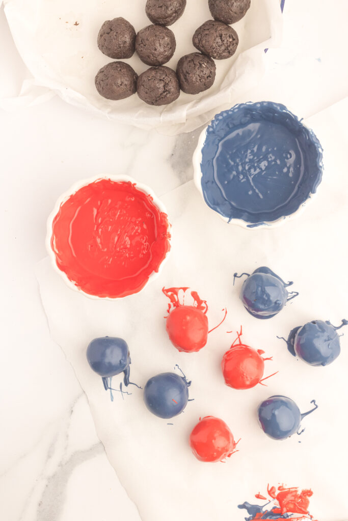 Red, white and blue oreo balls on a marble table.