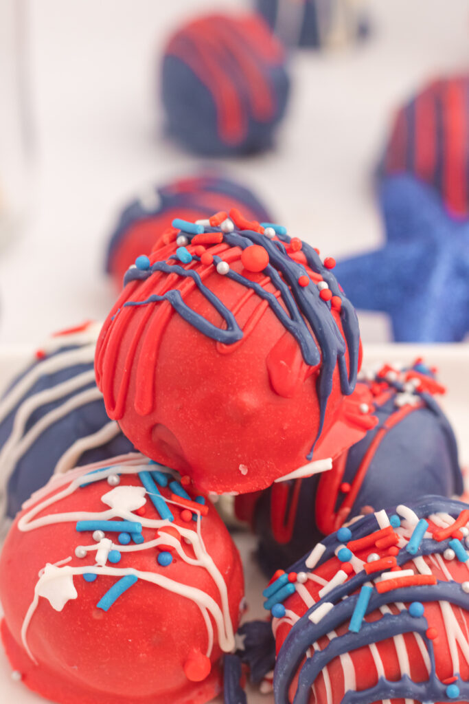 A table with red, white and blue decorations and a bowl of chocolate covered balls.